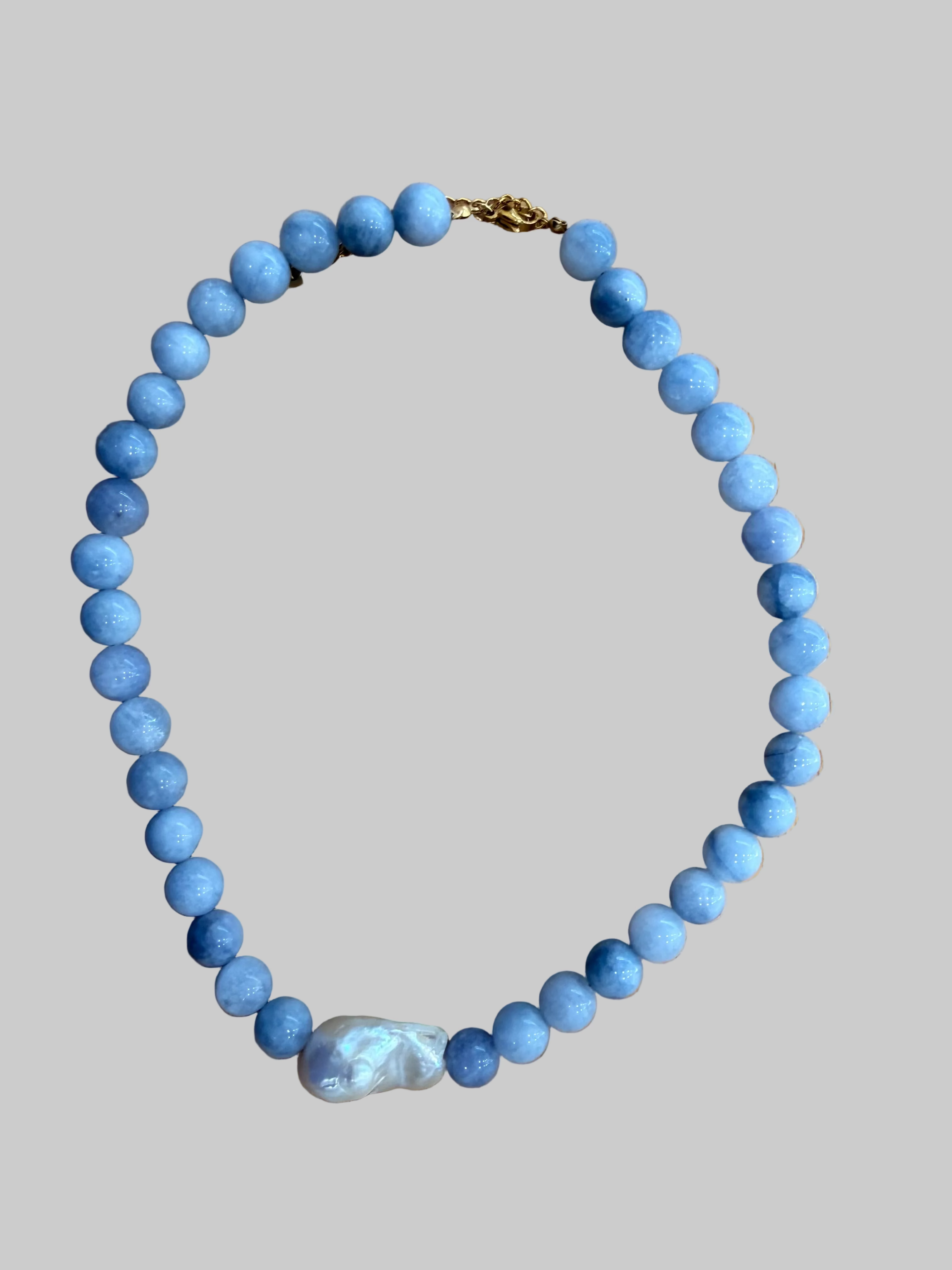 Blue beaded necklace with a white pearl pendant